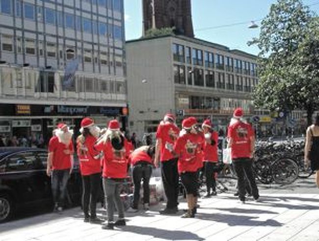 デパートÅHLENSの前にはたくさんのニセモノサンタが…。<br />なにかと思ったら、家電量販店のチラシ配りのバイト達。<br />チラシをもらって見たら”クリスマスプレゼントは是非当店で！”というような文字と、サンタの写真。<br />まだ夏なのに、やっぱりこちらはクリスマスへの気合いが違う…。<br />学生の夏休みバイトだろう若者達は暑いなかつけヒゲに帽子で、「God Jul!（スウェーデン語でメリークリスマス）」なんて言いながら楽しそうにチラシを配ってました。 