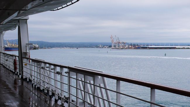 右舷側から眺めた風景です。<br />マオリ語で「カヌーを休める安全な場所」の意で、細長い半島によって波静かな、天然の良港となっています。<br />羊毛・食肉・木材等の輸出が盛んなところです。