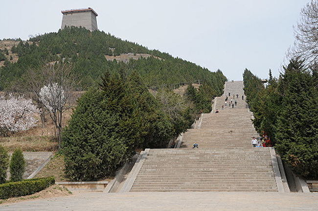 さて、乾陵（けんりょう）の御道（参道）下の駐車場に到着。<br /><br />ツアーで乾陵（けんりょう）に行くと、この画像で見えている西乳峰闕楼向こう側にある上の駐車場から歩き始めるようですが、SUR SHANGHAIはここから全部徒歩で高宗と則天武后を合葬した北峰まで上って行ってみます。(^_^)v<br /><br />下の駐車場から上の駐車場までのこの階段は全部で５００段以上あるので、上の駐車場まで連れて行ってくれるという車の勧誘もあります。有料ですが、歩くのが苦手な方は使ってみてもいいかも。<br /><br />チケットは、下の駐車場ではなく、上の駐車場そばのブースで買うようになっていました。０８年３月下旬は、４６元という半端なお値段。<br />どちらの駐車場にも、簡単な食堂や売店、トイレがありましたよ。