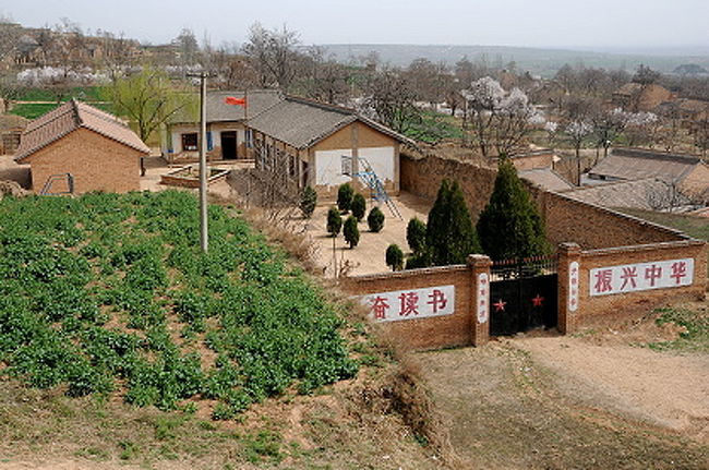 西乳峰闕楼と東乳峰闕楼の間を通る御道（参道）の階段途中から見えた景色。<br /><br />レンガ塀に囲まれたこの建物は学校。山の分校っていう感じだね。<br />学校の名も生徒たちも見えないけど、まだ授業中の小学校かな。<br />国旗が軽やかに翻っているのがのどかな眺め。<br /><br />でも、校門のあたりに書かれた言葉で、教育には力を入れているのがよく分かる。将来、この学校出身の有名人が出るかも。