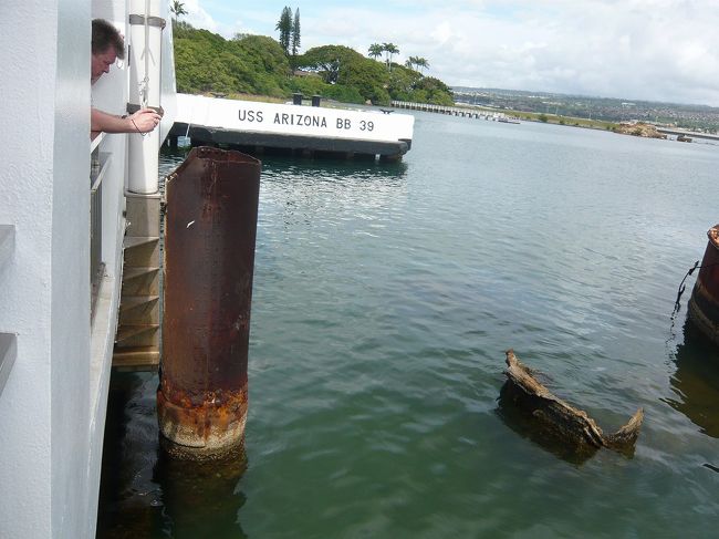 記念館の中央に掲げられている星条旗の根元部分に海面から円筒が突き出している。この円筒は当時の旗の掲揚台だった。奥にはアリゾナの埠頭位置を示すコンクリート台が見える。 <br /><br />