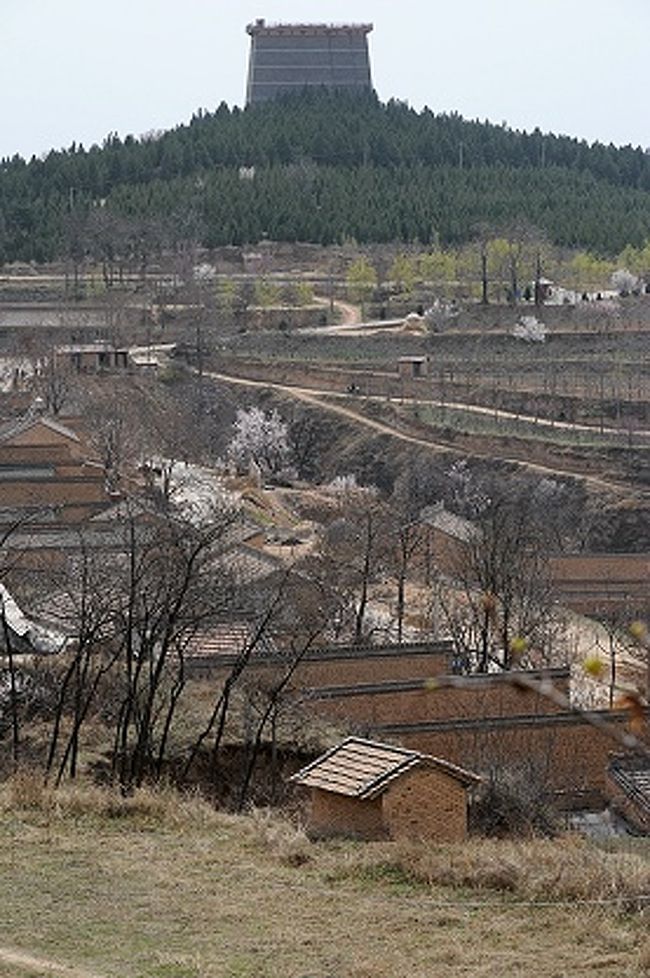 乾陵（けんりょう）の司馬道から眺めた西乳峰闕楼。<br />闕楼と言うのは、上の方でも言ったように、物見台として使われた楼閣。<br />現在見られるこの姿は近年の複製と言うことです。<br /><br />画像手前には、司馬道に沿った民家が見えています。<br />この中には中国中央部の黄土高原でよく見られる形態の洞窟住居窰洞（ヤオトン）も混じっているんですが、それはこの旅行記の後半でご紹介しようと思います。