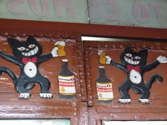 路地のバーの入り口にかわいい絵が。<br /><br />クスケーニャビールで乾杯していますね。