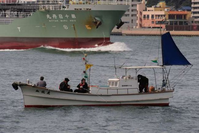 関門海峡で大型船の側で釣りを楽しむ人たち