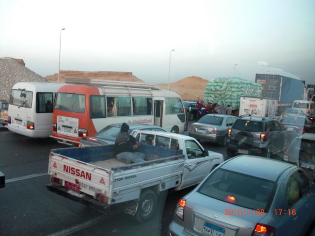 帰りは、大渋滞！<br />一応この道路。3車線の線が引いてあるのですが<br />線は、関係ありません…<br /><br />帰宅ラッシュ時間ということもありますが<br />今夜はエジプト対アルジェリアのサッカーの試合があるらしく<br />帰宅を急ぐ人で、更に大渋滞。<br />殆どすすまないので降りて <br />国旗と笛鳴らして、踊り始めたり… <br />別のトラックに乗ったり。 <br />やりたい放題ですね。 <br /><br />道端では、国旗が売ってます。 <br /><br />