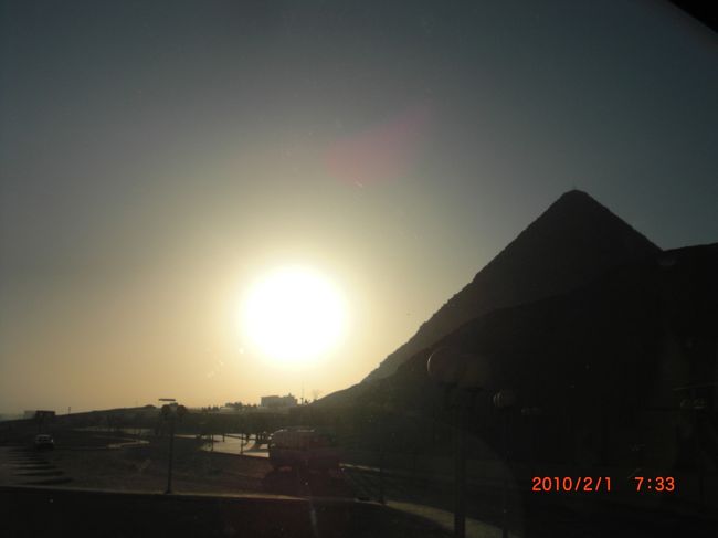 朝の太陽とクフ王のピラミッド<br /><br />近〜〜〜い！！　でっか〜〜〜い！！ <br />ピラミッド保護のために、毎日限定300人しか入れません。 <br />午前150人、午後150人です。 <br />他の観光施設は、前もって用意されたチケットを添乗員から貰うんだけど <br /><br />ここでは、本人の確認があるらしく、 <br />観光客でも１人ずつ買うらしい <br />チケットを買うのに添乗員さんとともに並ぼうとしたら… <br /><br />なんと、サポートミドさんが賄賂を渡して（？） <br />先に買ってくれてた（笑）！ <br />おかげで、混雑前にピラミッドとご対め〜〜ん。 <br /><br />