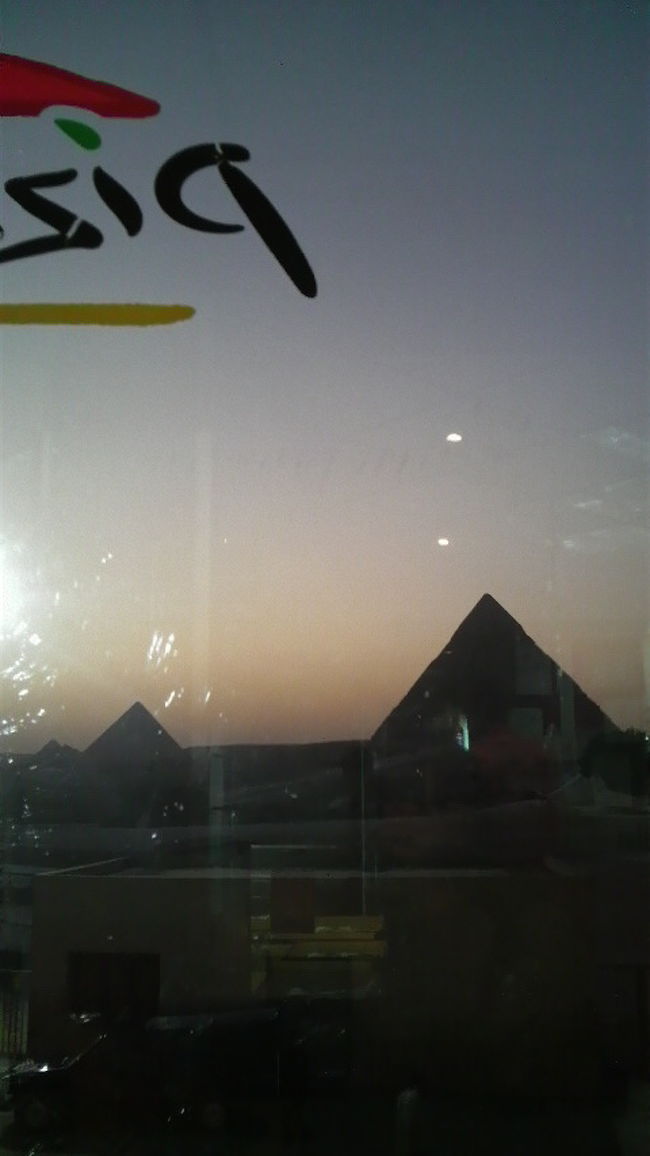 どうせならスフィンクスを見ながら食べよう!<br /><br />なんて思ったけど、<br />これまた、エジプト政府が作ったであろう強烈に明るいライト（左に見える光）が店内に向けて設置され、見えません。<br /><br />せっかく、音と光のショーをみようと思ったのに…<br />ま、そういう人がいるから　設置されたんだろうけど。<br />ショーが始まるまでは、スフィンクス見たっていいじゃないか〜！<br /><br />そんなこんなで、写真はあまり撮れず。<br /><br />この席は、スフィンクスが見つめている席の１階下のテーブル。<br />お客さんがいないからなのか、３階建の３階部分はＣＬＯＳＥしてたんだけど、カメラ持ってる店員さんが気付いてスフィンクスの視線の３階に案内してくれましたが、<br />誰もいなくて、男性店員さん（やさしそうだったけど）と２人になってしまうので、やめました。<br />自意識過剰と思うかもしれませんが、念のため☆<br /><br />視線の先はきちんと、特別テーブルが用意されてました。<br /><br />さて〜、今夜は早めに寝ようっと!