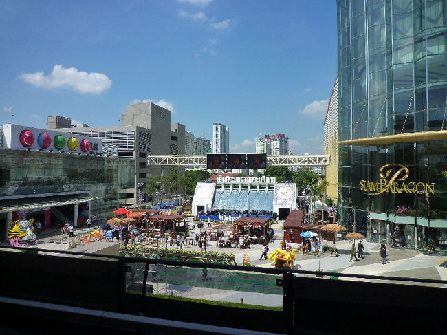 冷たい＆甘いものを食べて体力回復！！ <br />次もデパート巡ります。 <br />Siam駅に戻り、お隣のChit Lom駅へ向かいます。 <br /><br />さっきのひまわりがあった広場を駅からパシャリ。 <br />何かのイベントがあるみたいでした。 <br /><br />この二駅の間はBTSの下に歩行者専用通路が作ってあり、日差しも車の排気ガスもよけて歩ける（笑）ので便利です。 <br />…が、足が痛い（3日目には母も足が痛くなってましたｗ）ので1駅移動でもBTS使ってましたｗ <br />大手デパートなんかは直接通路が作ってあるので、買い物で巡る人にはありがたい通路です（＾＾ 