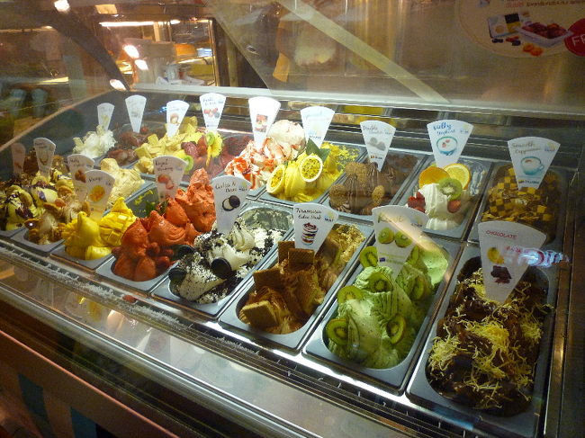 で、晩御飯を食べる前にうろちょろしていたら、母が偶然アイス屋さんを見つけて晩御飯決まるまえから「あのアイス食べて帰る」と心に決めていたようだったので、そのアイス屋さんへ。<br /><br /><br />…めっちゃ美味しそうじゃないですか？？？（ｼﾞｭﾙﾘ <br />店員さんに注意されるのも面倒くさいので、店員さんが会計行ってる隙に撮影してやりました（← <br /><br />お腹を満たし、ホテル出発1時間前にホテルへ戻り、再度パッキング！！ <br />余裕で荷物は入ったのですが… <br />…あれ？ <br />…これ、20kg超えてそうな気がする…（((´д｀)) ﾌﾞﾙﾌﾞﾙ <br /><br />母のキャリーとお土産のつもりでかった大きめのバッグに割り振りしつめ終えるも、もうチェックアウロの５分前…！！ <br />ドタバタしながらチェックアウトしに行ったら、今度は「お支払い700Bあります」と…。 <br /><br />え？なんで？？何も使ってないよーーーーーー！！！ <br />日本語全然できない人だったのですが、使ってないもんは断固として支払わんぞ！！日本人だってNOと言えるんだ！！（違）ってことで戦いましたｗｗｗｗｗ <br />拙い英語でやり取りし、ホテル側が間違ってたってことで何とか済みました。 <br />どうやら、別の部屋の人が夜にリムジンバス使って病院まで行ったらしく、その交通費が700Bだったようです。で、その部屋番号を間違って運転手さんが伝えたんだか、フロントがミスしたんだか私たちが宿泊していた部屋番号になっていて請求された…ってな感じでした。 <br />運転手と思われるおっちゃんまでフロントにやってきて、フロントの人とタイ語でやりとりしてたので詳細はわかりませんが、「送迎したのこの人たち？」「いいや、違うよ」みたいなやり取りしてました。 <br /><br />20分弱フロントでやりとりしてたんですが、その間うちのマイペースおかんは「お母さん足だるいから向こうで座ってるね〜」とやりとり開始2分ぐらいでいなくなり、やりとりを終えて母のところに行って事情を説明したら「お母さんだったら、そのまま700B払っちゃうよ、よくわかんないから」と。 <br />…この人は一人で旅させちゃいけない、と娘は心の中で思いましたよっと。 