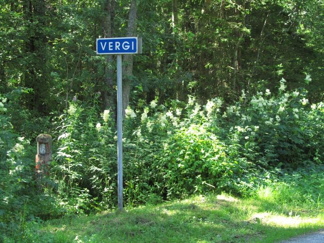 ヴェルギ村の看板と、花いっぱいの森林の道