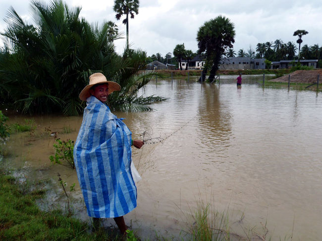 走ってる途中、近くの池で漁をしていた地元の人。<br />何を採ってるんだろう？