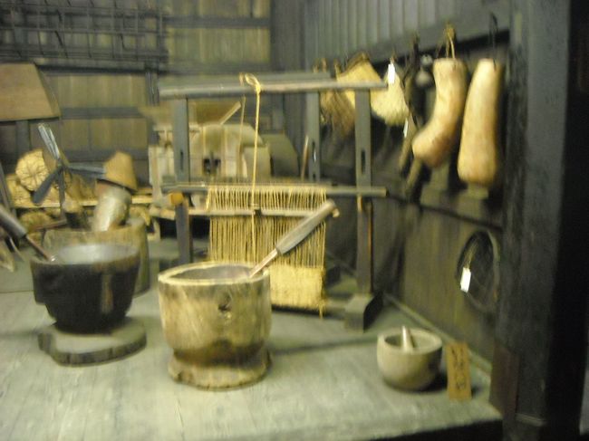 内部に展示してある昔の生活具。右下は石の鉢と石棒。ひょうたんの容器や臼と杵などが並んでいる。