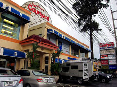 無事HOTELに辿りついたけど、ずぶ濡れの衣類をスーツケースには詰められないし、かと言って外は雨降っているから干しても乾かない（夫はデニム素材ハーフパンツを着用していて、ただでさえ重たいのに雨を含んで最悪な状態）。
ランドリーに出すと24時間後受け取りだから間に合わないので、私が念のため持ってきた洗濯ロープを使用することになった。
手洗いで洗濯し、エアコンをガンガンに付けて室内干しをする作戦。
大仕事を終えたものの、まだ友人への土産が購入出来てなかったので小雨の中、雨合羽を着用して再び出発。
到着したのはCentral　Festival向かいに建つコート・ヤード。
ここにはジム・トンプソンのアウトレットが入っていて他にも…