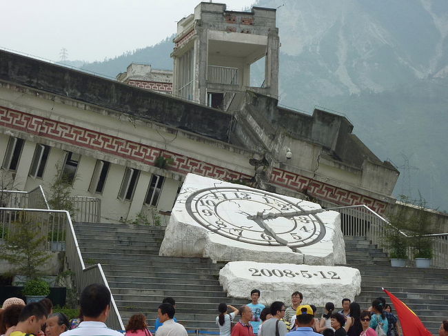 成都から登山の拠点、日隆へ。<br /><br />日隆は四川省の成都から２３０Ｋｍ程度、かなりの高地（海抜３０００ｍ以上）にある四姑娘山周辺の観光の町。<br /><br />途中、四川大地震の震源であった汶川県映秀鎮の地震跡を見学。<br />ここは地震の記憶を留めるため被災した建物などをそのまま保存して見学できるようにしている。<br /><br />http://blog.livedoor.jp/qz2010il/archives/1352667.html<br />
