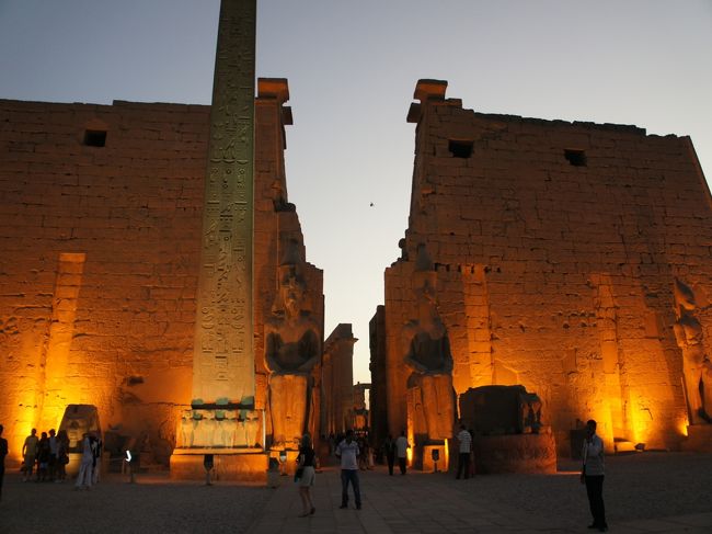 ルクソール神殿に入るころには日も暮れかけていました。<br />ライトアップが素敵。<br />これは入口。オベリスクが立っています。<br />元々は対になって立っていたというオベリスク。<br />右にあったものは、今はパリのコンコルド広場にあるものだそう。