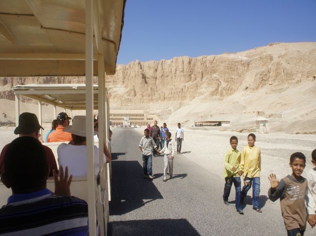 ホテルの朝食を終えたら、ロビーでガイドと待ち合わせ。<br />車に乗り込んだら、数十分。<br />ハトシェプスト女王の葬祭殿に到着。<br />なぜかたいした距離ではないけど、入口から遺跡そばまではこのような乗り物があります。