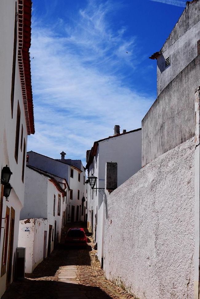 標高900m弱の小高い山の上にこの白い村はある。<br /><br />城壁で囲まれた村で、車を城壁の外にある駐車場に停める。<br />中に入れるのは住人の車だけのようだけど、<br />仮に入っていいよと言われたとしても、<br />こんな細い道を私は運転できない。<br /><br />真っ赤な車が私たちを追い越せるよう<br />壁にへばりつかなければならなかった。