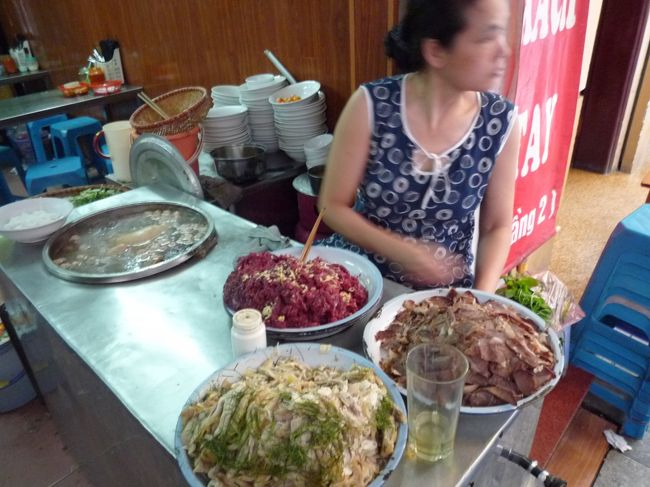 フォーの店頭で指差し注文。<br />赤い生牛肉と茹で牛肉と蒸鶏の3種の具。<br />周りの客見るとフォーボー食べてる人がほとんど。<br />じゃ、フォーボータイ2つくださーい。隣のカフェにいるからねー♪とご注文。