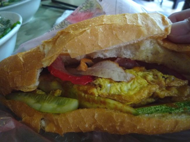 カフェに持ち込んで頂きます♪<br />各種お肉と卵、キュウリ。<br />パクリ。よかった、アジノモト味はしません（笑）<br />おいしいけど、やっぱりパクチーもナマスも入らないからちょっと寂しい。。<br />ハノイ式バインミーは噂どおり超シンプル。大体バインミー屋があまりない。<br />ノラ的にはいろんな具材のハーモニーが味わえるサイゴン式のが好きだなあ。<br />