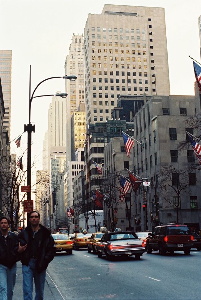 上と同じ場所で2〜3秒後の写真です。黄色の車も人物も同じです。<br />ビルが高い街には縦の構図が似合いそうです。