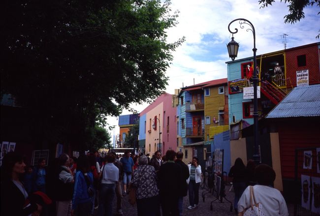 【Caminito】<br /><br />カラフルに塗られた家が並ぶカミニート。<br />ブエノスアイレスで最も有名な観光地といえばカミニート。港沿いの下町ボカ地区にある小さな通りのこと。赤、青、黄、緑など、カラフルにペインティングされた家が並ぶ。もとは、この地に生まれた有名な画家キンケラ・マルティンのアイデアによって作られた通りだとか。通りには土産物を売る屋台が並び、広場ではタンゴダンサーたちが客寄せをかねて踊ったり一緒に写真を撮ったりしているのも名物のひとつ。<br /><br />