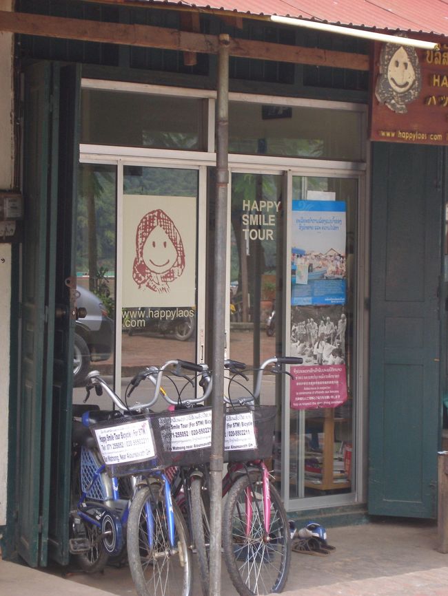 旅行会社ハッピースマイルはルアンパパンのメコン川沿いの道Manthatoulat Rd.にあります。有名なレストラン　エレファントからメコン川に向かって歩き川沿いの道を右折してすぐです。日本人の伊○さんは関西なまりのある方で，ラオスのいろんなことを教えてくれるやさしい方です。“明日も日本語ガイドの手配が付く。”と言うことでさっそく翌日出発することにしました。頑張って負けてもらって日本円21000円にしてもらった。水や食料，寝袋は用意してくれるとのこと。ただ，村まで歩かないと行けないトレッキングのことを心配してくださっていたので、昨年のネパールでの山歩きの苦労が思い出され、帰りがけにさっそく登山用のストックを市場で（日本円にして）約１２００円で購入。皆で食べれる様日本のお菓子もできるだけ持って行きたかったが荷物を減らすことにつとめ最低限の物だけにした。（あとで振り返ると行きだけは村の人が荷物を取りに来てくれるので　向こうで消費する物はもっと持って行ってても大丈夫だった。）