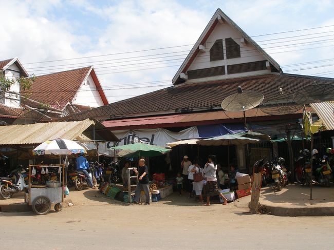 ８月２６日朝，宿泊しているコールドリバーゲストハウスに朝８時半に車でピックアップに来てくれるとのこと。大きな荷物はゲストハウスに預け，必要な荷物と昨日買ったストックを持って迎えが来るのを待っていた。前日、ひどい夕立があったので天気が心配。昨日みたいな雨だと傘だけではだめで雨合羽が必要に思えるが用意していないどうしよう，などと考えているとゲストハウスの親父は今日の降雨確率４０％、明日は８０％とネットに出ていたよと教えてくれる。そんな心配をしていたら，約束の時間をかなりすぎても迎えがこない。やがて例の伊○さんがバイクで来て車がトラブルで遅れていることを謝りに来た。ついでに旅行会社によってくれれば雨合羽を貸してくれるとのこと。そうこうするうちに迎えが来た。ガイドの方は熊本に住んでたことがあったり，奥さんが日本人だったりするのでものすごく日本語が上手だった。ハッピースマイル社によって合羽を借りた上，出発。<br />まずは村での食事の材料をルアンパパンの市場で買ってそれを持って行くとのこと。タラート　ポーシーと言うマーケットに行って買い物。ラオスの人の買い物につきあうというのもこれまで経験なし。ちょっとワクワクする。