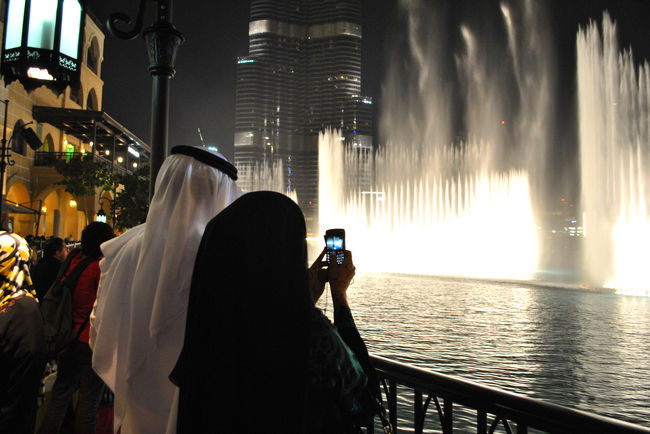 噴水を撮影するアラブ人カップル。