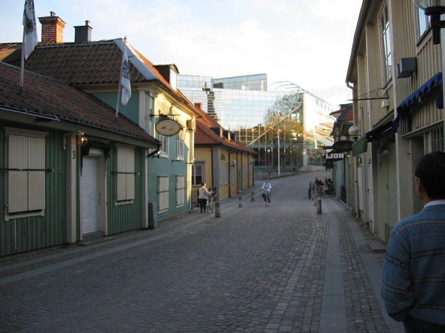 古い感じの街並みの向うにガラスの建造物があります。