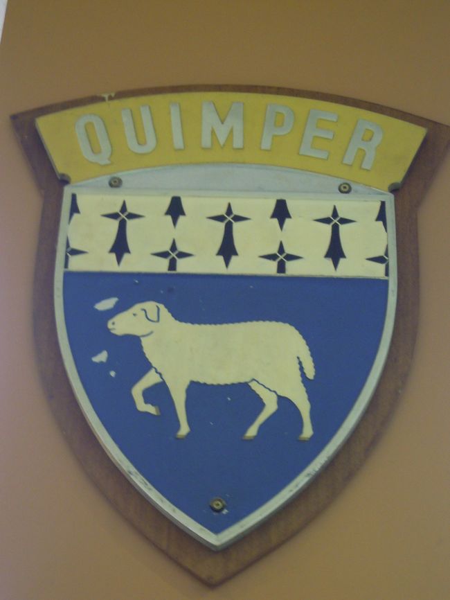 カンペール駅構内の柱に飾られているカンペールの紋章。<br /><br />なぜ白い羊なんだう?<br /><br />羊の上の描かれている黒い模様はブルターニュの旗の左上に描かれている「白イタチの黒い尻尾」<br />白イタチはかつてのブルターニュ公国の紋章。