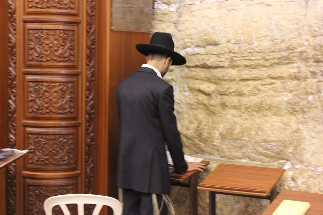 壁の横には洞窟のようなものがあります。<br />その中では多くの人が聖書を読んでいます。