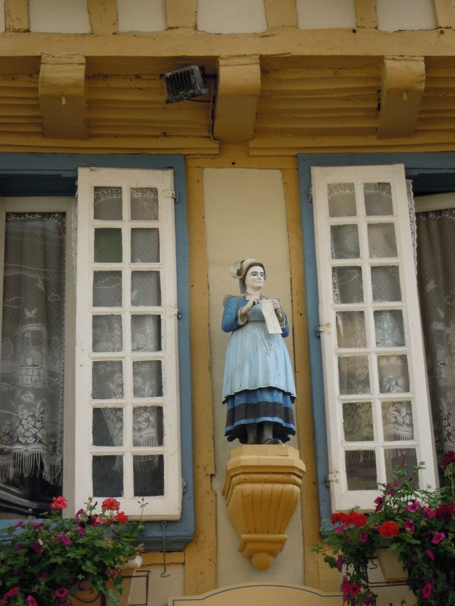 サン・コランタン大聖堂の前は広場になっていて、<br /><br />木組みの家の一階はカフェやお店、二階は住まい。<br /><br />見上げると窓にはブルトンの衣装を着けた人形たちが飾られています。<br /><br />サン・コランタン広場、広場からまっすぐ通っているケレオン通りを中心に四方にめぐらされた小道には木組みの家が並んでいます。<br /><br />かなり立派な木組みの家が多くブルターニュのフィニステールの中心地コルヌアイユ伯爵領として栄えていただけのことはあります。