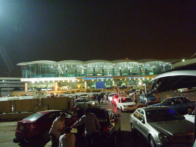 24時間かけてカイロ空港へ到着。<br /><br />到着したら、パスポートコントロールを通る前に両替所に向かってVISAをGet（VISAはUS$15)US$20を出すと、US$でお釣りをくれる。<br />そしてパスポートコントロールの前にあるATMでエジプトポンドを500ポンドほどおろす。<br /><br />制限エリアを出ると、一気に右から左から「タクシー？」「タクシー？」と声がかかる。あ〜〜久々、この喧騒。大量のタクシー？Call。<br /><br />疲れた体でタクシーとファイトするのは嫌だったので、今回はオクトパストラベルで既に送迎手配済み。<br />自分の名前のボードを探して、タクシー？と合唱している奴らを無視して空港を後にする。