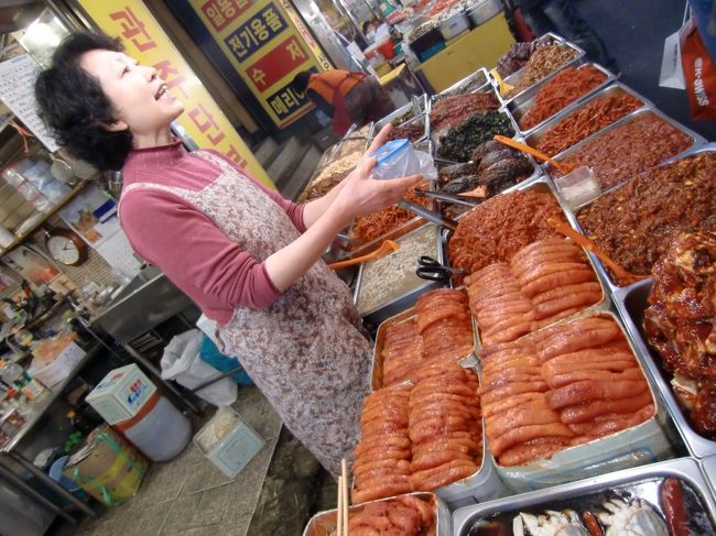 お土産にキムチを買いました。<br /><br />ガイドブックにも載っている有名なお店「洪林」（ホンニム）。<br />優しいアジュマがどんどん味見を勧めてきます。<br />そして何故か「ヤクルト」も頂けます。<br />私はオレンジジュースも頂きました。<br /><br />ちなみに、定番の白菜キムチはありません。<br />タコ、イカ、カニ、朝鮮人参、切干大根、さきいか、エゴマなど、日本ではあまり馴染みのないキムチばかり。<br />しかも、美味しいのなんのって。<br />ついつい、たくさん買ってしまいます。<br /><br />買いすぎてしまっても大丈夫。<br />お店からEMSで日本に送ってもらいましょう。