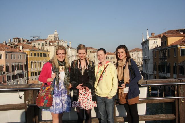 アカデミア橋の上で出会った人々。8：59<br />4人の写真を撮ってあげたついでに撮りました。<br />People and I took a photo each other on Ponte dell'Accademia .<br /><br />二人がCANON EOS一眼レフの愛用者です。<br />一眼レフでの撮影はモニターではなくファインダーを覗きながら写すのが一般的でコンパクト・デジカメと撮り方が大きく違うので、一眼レフの所持者同士でないと撮影を依頼しづらいものです。 <br /><br />