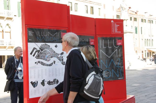 サント･ステファーノ広場でヴェネチア・ビエンナーレ（隔年展）ILUMI NAZIONIの案内に見入る人。