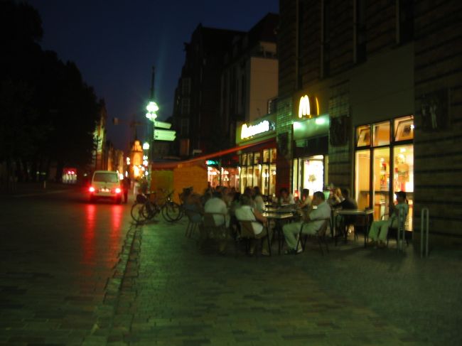 夜のロストックの町（手ぶれしています）。<br />暗い中で屋外カフェでくつろいでいる人達がいました。<br />その後、ホテルに戻り就寝しました。