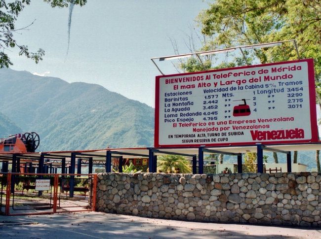 メリダにある世界一長いロープウェー<br /><br />ハイキングで距離を歩くのはＯＫですが、根が面倒くさがりなので山登りは敬遠しています。なのに5000ｍ級の山に登る気になったのは、ロープウェーで4700ｍ辺りまで行けるから。しかし、メリダ到着時に空港のインフォメーションで尋ねたらメンテのため動いてないという返事。念のため翌日来てみましたが、やっぱり休止中でガッカリ。<br />諦めきれず近くの旅行代理店に寄ってみると、ロープウェーの通常料金に比べたら破格（当時の120US$相当）でしたが行けるとのこと。ヤッタ〜\(^o^)／<br /><br />ちなみに看板に記されているように、全長約12.5ｋｍ、標高差約3200ｍという凄い代物。しかも1958年製です。<br />