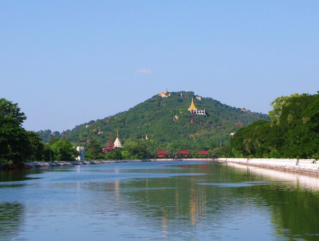 １１月５日（土）<br />１４時、シュエナンドーとアトゥマシーの両僧院を見学した後は、引き続きサイカーに乗ってマンダレー市内を観光。<br /><br />市の中心部にあるミャンマー最後の王朝コンバウン朝（１７５２−１８８６年）の王宮（旧王宮）へと向かいます。<br /><br />旧王宮の周囲には堀がめぐらされており、入場できるのは東側に架かる橋からのみなので、そこを通って中へ入ります。<br /><br />橋の北側にはところどころに金色のパゴダがそびえる仏教の聖地である丘、マンダレーヒルが見えます。