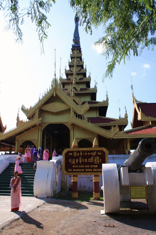 東の入口から１０分ほど歩いて、ようやく旧王宮を再現した建物群の入口までやってきました。<br /><br />えんじ色の屋根に対して、破風や鼻隠はパゴダと同じように金ピカに輝いています。<br /><br />ピンクの僧服を着た尼僧の一団もちょうど訪れたところで、記念撮影などを行っていました。