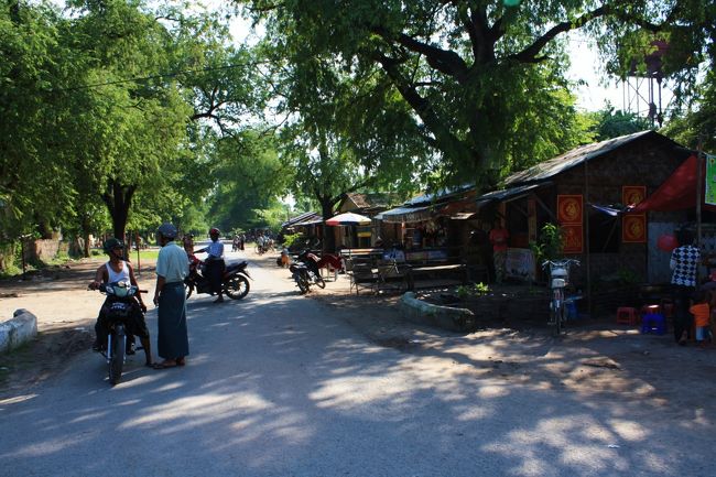 先ほどのシュエナンドー僧院で買ったカード大のマンダレー入域証明を入口で提示し、サイカーを降りてサイカーこぎのおじさんとともに門をくぐってみると、道の両側には緑の木々とともに民家や商店のようなものがいくつか並んでいます。<br /><br />バイクも走っているし、ここにも普通の市民（もしかしたら軍関係者のみ？）の日々の生活があるようです。<br /><br />・・・訪れる前は旧王宮は敷地全体が大きな観光施設だと考えていたので、こうして暮らしている人がいるなんて思ってもみませんでした。