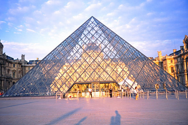 ここがルーブル美術館の入り口。<br />　今回、運の良いことに、パリ到着翌日がルーブル美術館無料開放の日であった。投宿したリュクサンブール宮殿すぐ近くのホテルからルーブルまでは歩いても１０分ほど。美術館が開く時間より１時間も早くホテルを出た。ルーブル美術館、特にその無料開放の日はスムーズな入場が困難と聞いていたためである。<br /><br />　案の定、ルーブルのピラミッドにある入場口から百メートルほど列が出来ている。が、まだ開門前なので、このくらいの列であればたいしたことはない。私が列の最後尾に着いたあと、あれよあれよという間にその最後尾は見えないところまで延びていった。