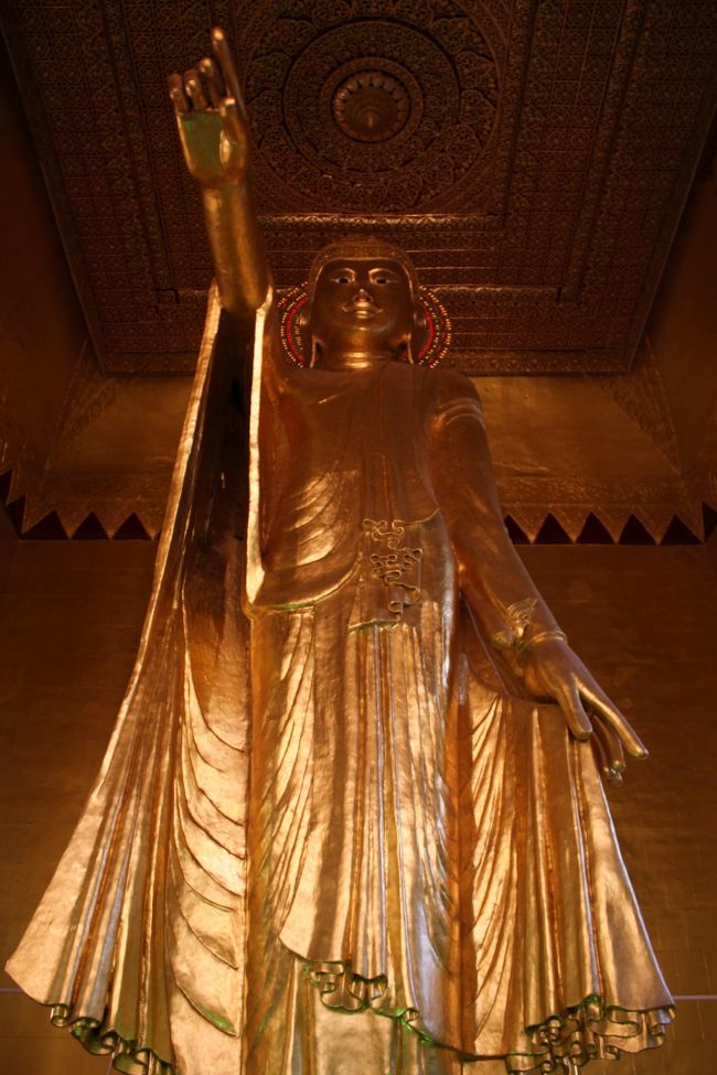 下から見上げた“予言を与え給う仏陀”像。<br /><br />この位置からは、まるで天を指し示しているようでもあります。<br /><br />この像が実際に指差しているのはマンダレーヒルの南の旧王宮の方向で、お布施するものが何もないことに悩んだあげく自分の乳房を差し出したサンダームキ（女鬼）に対し、“おまえは来世で王になりそこ（指差した方向＝旧王宮）に街を作るだろう”と予言を与え給うた仏陀の姿を表しているのだそうです。<br /><br />この予言を人々は信じ、マンダレーに遷都し街を築いたミンドン王はサンダームキの生まれ変わりだと言われているとのこと・・・どの国でも英雄に神話はつきものですね。