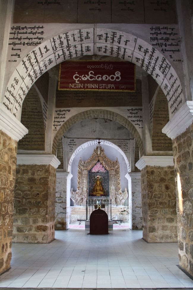 続いて現れたのがンコンミーンストゥーパ（Ncon Minn Stupa）。<br /><br />“ウズラの仏塔”という意味だそうで、これは、仏陀が人間として転生する以前に経た何種類もの動物にウズラが含まれていて、そのウズラの像がここに祀られていることから来ています。<br /><br />一方で、それよりも印象的なのが、白い壁面にぎっしりとビルマ文字が刻まれたアーチの群れ。<br /><br />独特のアーチ構造をもち、偶像崇拝を禁じたことから文字の芸術が発達したイスラム建築のようでもあります。<br /><br />ただ、刻まれている文字はお経の言葉かと思ったら寄付者の名前だそうです。<br /><br />その辺がイスラム建築とは違うところか・・・。