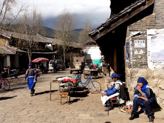 　しかし、それらの衣装は普段着ではありません。ナシ族のお婆さんたちがよく着ているのは、青い人民帽と青いエプロンの地味な服装(写真)。すこし田舎の村に行けば、ポツポツ見かけます。しかし、この作業着のような格好を民族衣装と呼んでいいのかどうか..ちょっと微妙です。<br /><br />　麗江では、古城内の家庭旅館に宿泊しました。オーナー家族はナシ族でしたが、服装も文化も食べ物も漢族と何ら変わらず。全く得るものなし！<br />