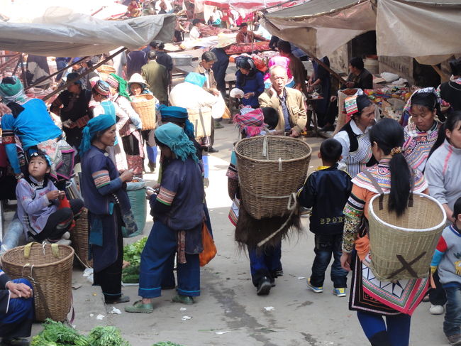 　今回、私が訪問した４つの定期市を紹介してみたいと思います。 最も便利なのは、ほとんどの旅行者が滞在する新街で行われる定期市。頻度は４日に１回。場所は雲梯順捷酒店(旧政府招待所)横から続く坂道を下った先にあります。ここに集まるのは主にハニ族(写真左)とイ族(写真右)の女性達。タイ族やランテン・ヤオ族もたまに見かけます。<br /><br />　露店は長い坂道に沿って並び、買い物カゴを背負った女性たちが階段を昇り降りする様子は絵になります。