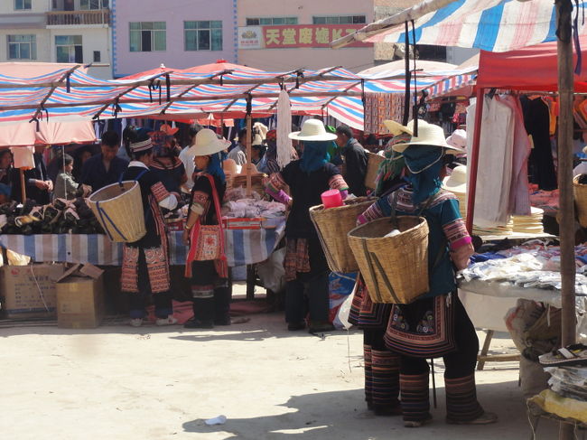 　ここに来るのは主にハニ族とイ族。ハニ族の服装は新街と違い、黒に赤い刺繍を入れたものがマジョリティです。日差しが強いので、スカーフの上に帽子をかぶります。