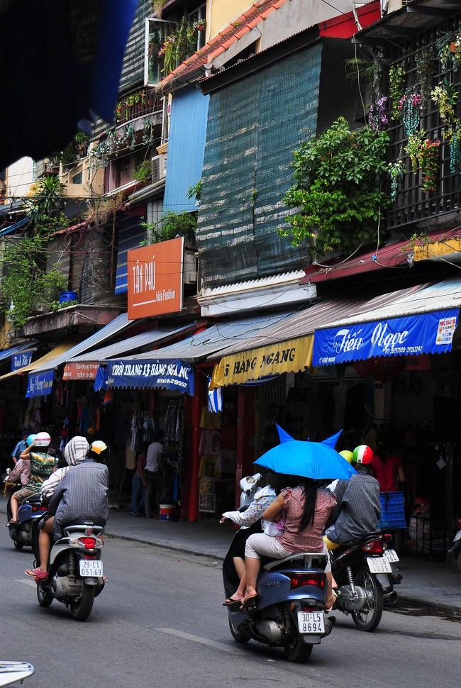 変な形の傘をさしている原チャ。<br /><br />うわさには聞いていたけど、原チャが超多くて、最初は通りを渡るのが怖かった。でも2,3回わたるとすぐに慣れます。<br /><br />コツは、走ったりすると逆に動きが予測しづらくなって危ないので、堂々と歩いて渡ること。