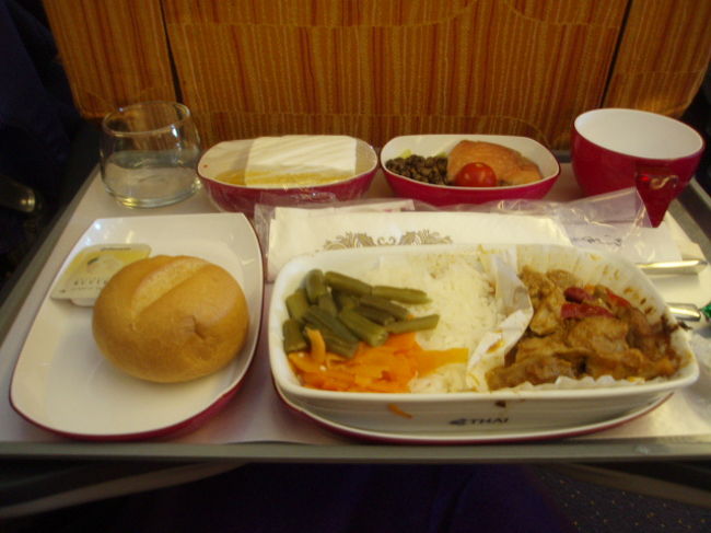 TG643便にてバンコクへ。初めてのタイ航空。機内は紫がメインカラーでエキゾチックでした。機内食はチキンカレーと白身のお魚の選択。やっぱりバンコクだったら、カレー？ということでチキンカレーにしました。<br />