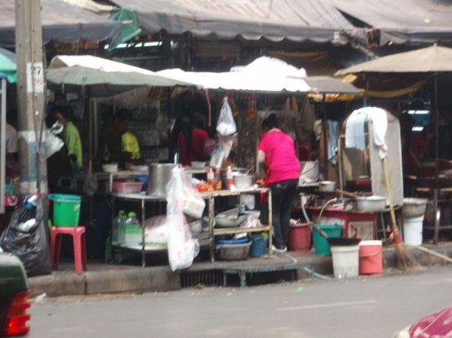 ラーチャウオンに到着。歩道は屋台でいっぱい。前を歩く人の背中しか見えない。これから、お昼を食べに行きます。今日は焼きエビが食べたい。ということで新明財というお店に行きます。